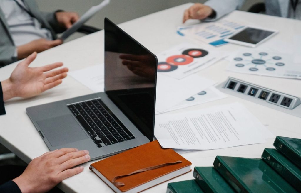 Quy trình tư vấn — bàn họp với hồ sơ và laptop